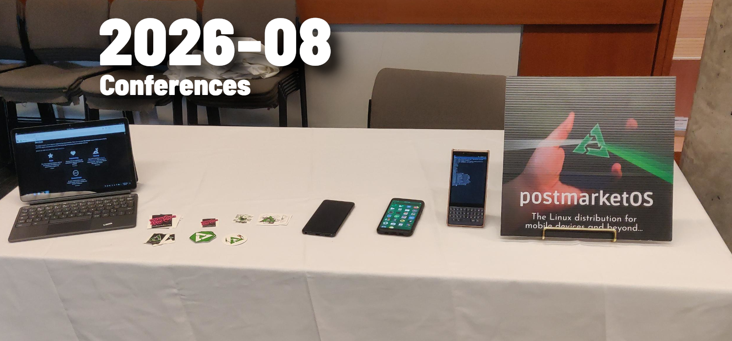 Table with a postmarketOS album-art like image in front along with a couple of phones, stickers and a convertible